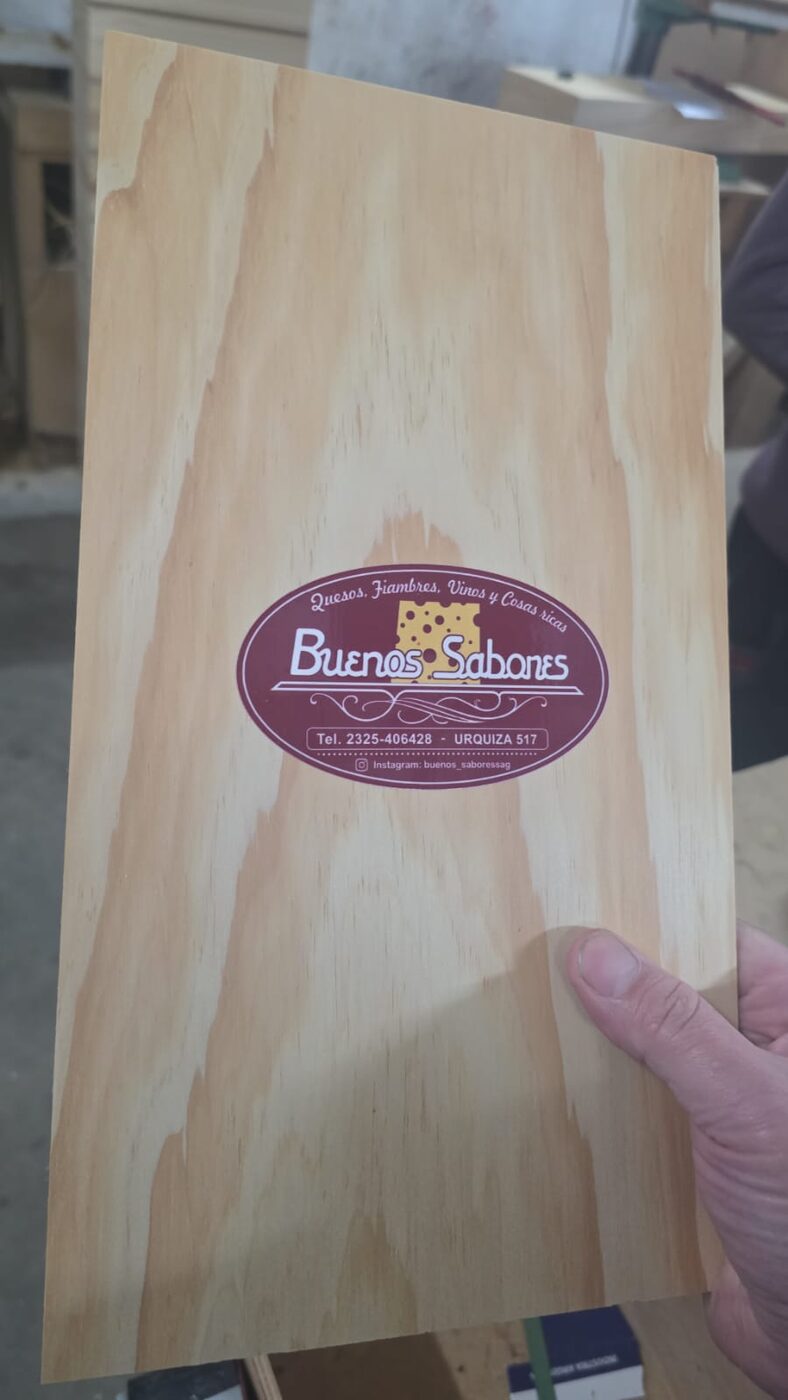 Tabla de presentación Buenos Sabores sostenida en mano en el taller