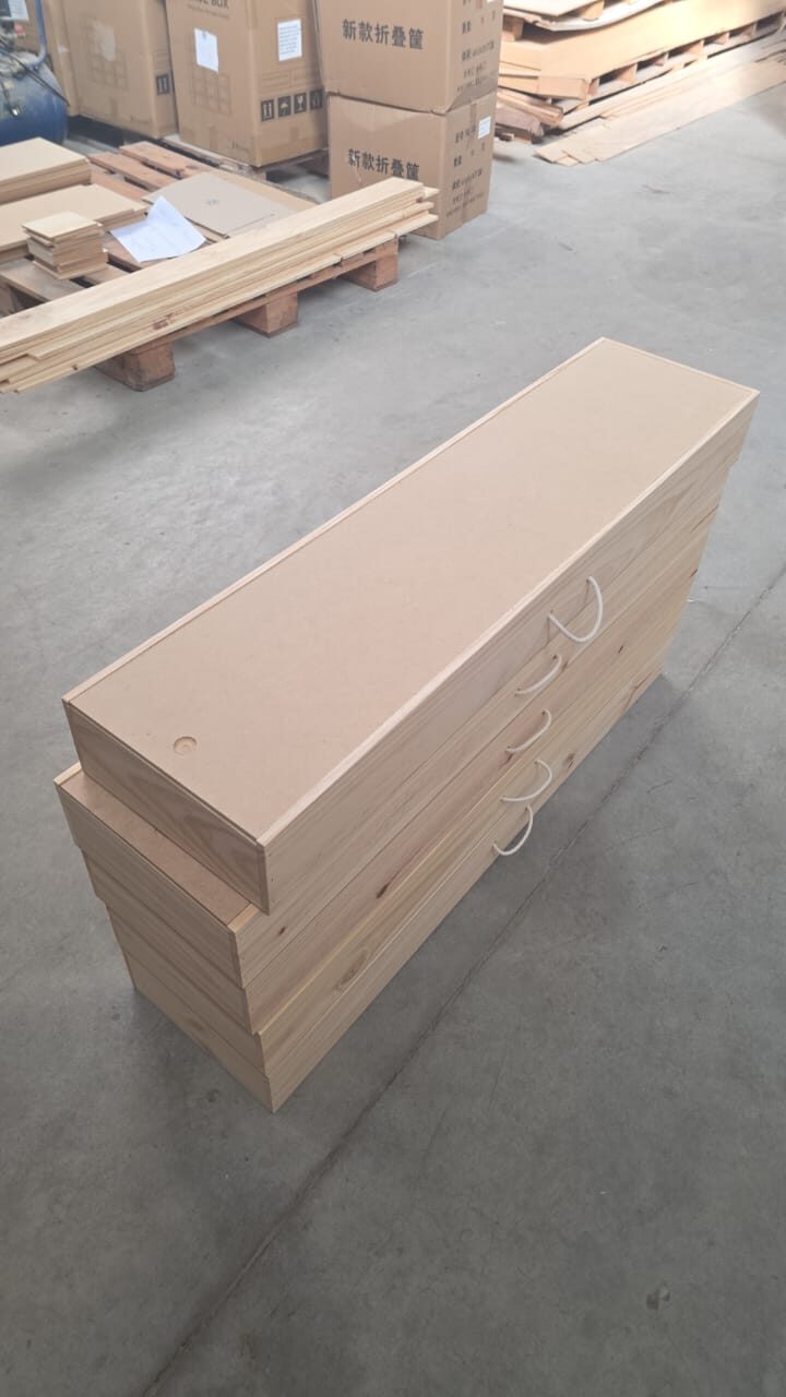 Cajas vineras individuales largas en proceso de armado sobre la mesa del taller